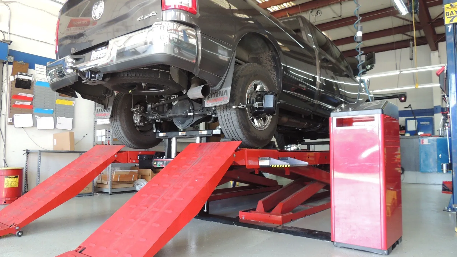 A clean professional auto service bay with a vehicle raised on a lift