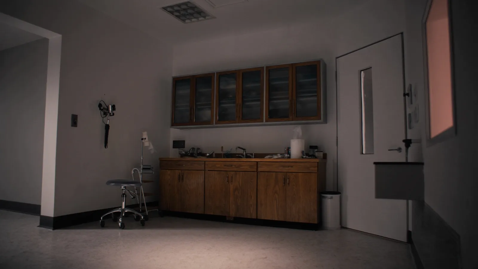 A calm modern clinic exam room with warm wood accents and soft light